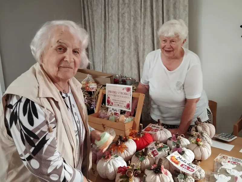 Dvě seniorky u stolu s ručně vyrobenými dýněmi
