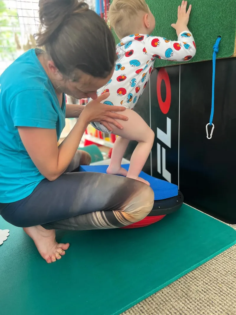 Maxík se při rehabilitaci drží stěny a učí se stát