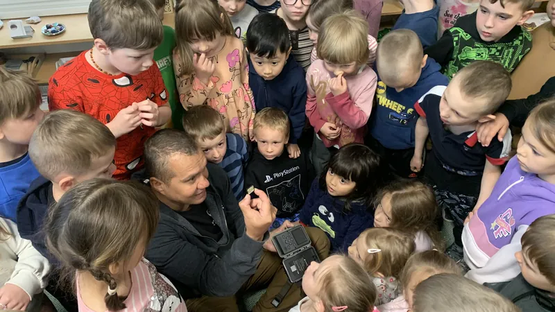 Děti ve třídě obklopují lektora s fotopastí